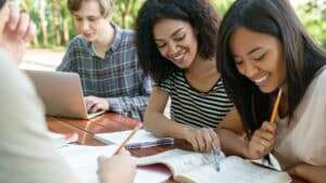 imagem mostra alunos sorridentes estudando para intercambio
