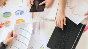 Imagem mostra um grupo de pessoas estudando e analisando gráficos